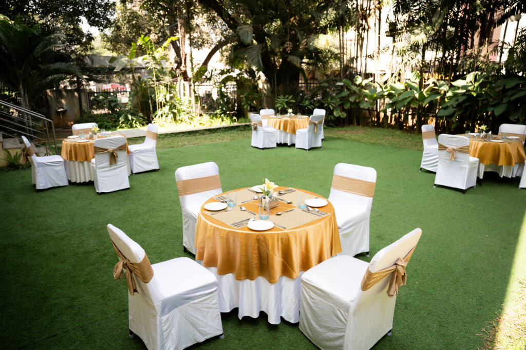 Lawn dining set-up with round tables at Augusta Club, JP Nagar